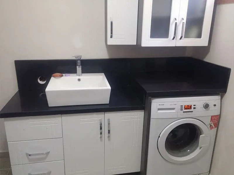 Siyah lavabo tezgâhı ve tezgâh üstü lavabo, çamaşır makinesi bölümü